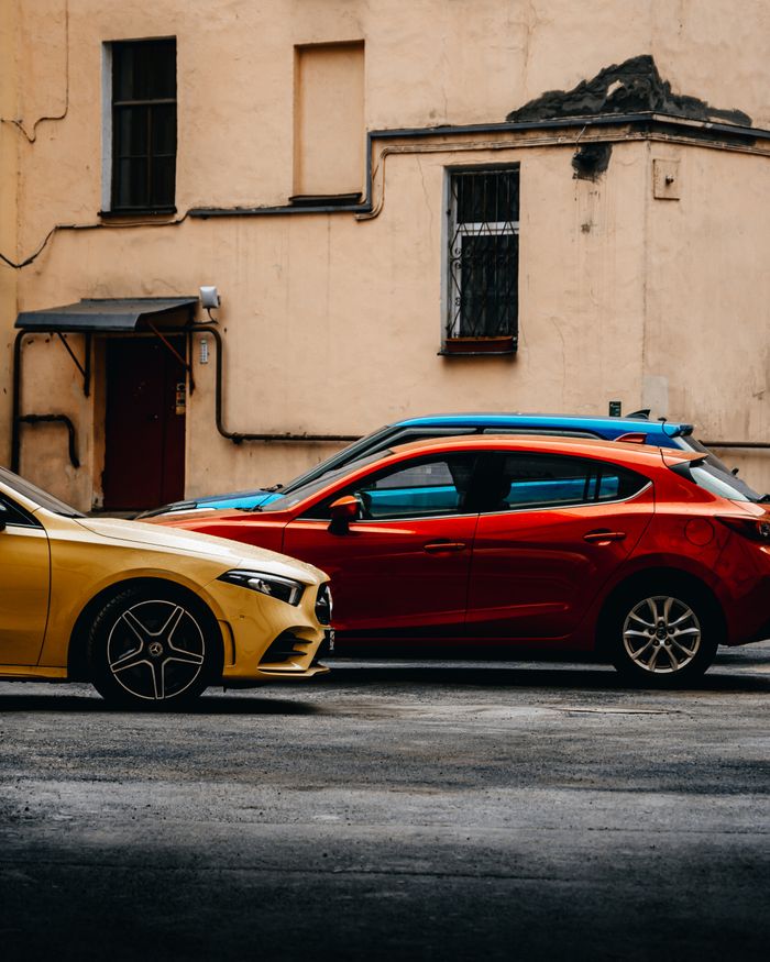 Bright yellow and red cars parked along an urban street in Saint Petersburg.