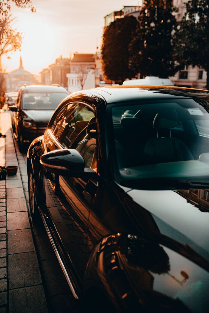A sleek black car parked on an Istanbul street, captured at sunset with a warm, urban ambiance.